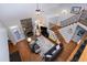 Open living room with stone fireplace, hardwood floors, and staircase with wooden railing and iron spindles at 3655 Pleasants Ridge Dr, Wake Forest, NC 27587
