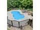 Kidney shaped in-ground pool surrounded by concrete, black fencing, and lush greenery at 3655 Pleasants Ridge Dr, Wake Forest, NC 27587