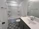 Bathroom featuring double sink vanity, shower-tub, and decorative flooring at 380 Pecan Valley Way, Four Oaks, NC 27524