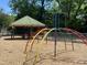 Playground equipment featuring a climbing structure with a metal roofed picnic table in the background at 380 Pecan Valley Way, Four Oaks, NC 27524