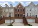 Exterior showcases brick townhomes featuring attached garages, landscaped entrances, and eye-catching architectural details at 4020 Abbey Park Way, Raleigh, NC 27612