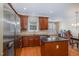 Kitchen with stainless steel appliances, center island, and dark wood cabinets with lots of natural light at 4020 Abbey Park Way, Raleigh, NC 27612