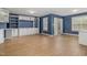 Spacious living room featuring custom built-ins, laminate floors, large windows, and a rear exterior access door at 4020 Abbey Park Way, Raleigh, NC 27612
