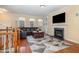 Living room has a fireplace, hardwood floors, large TV and large windows bringing in plenty of light at 4020 Abbey Park Way, Raleigh, NC 27612