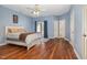 Main bedroom boasts hardwood floors, a ceiling fan, and a private balcony for relaxing outdoor space at 4020 Abbey Park Way, Raleigh, NC 27612