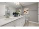Bright bathroom features double vanity with modern fixtures, white cabinetry and tiled shower at 408 Providence Spring Ln, Fuquay Varina, NC 27526