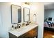 Bathroom featuring double vanity, black fixtures, framed mirrors and view of bedroom in background at 48 Blue Heron Ln, Roxboro, NC 27574