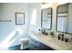 Bright bathroom featuring double sink vanity, black fixtures, framed mirror and hexagon tile flooring at 48 Blue Heron Ln, Roxboro, NC 27574