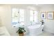 Beautiful bright bathroom showcasing a stand-alone tub, white tile, and natural light at 48 Blue Heron Ln, Roxboro, NC 27574