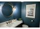 Stylish powder room featuring a round mirror, elegant lighting, and modern fixtures, offering a touch of luxury at 48 Blue Heron Ln, Roxboro, NC 27574