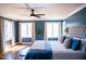 Comfortable bedroom boasts a large bed, a ceiling fan, and natural light from large windows at 48 Blue Heron Ln, Roxboro, NC 27574