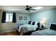 Cozy bedroom with two beds, a ceiling fan, and soft lighting, perfect for a relaxing and restful night's sleep at 48 Blue Heron Ln, Roxboro, NC 27574