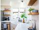 Bright kitchen featuring white cabinets, farmhouse sink, and ample sunlight at 48 Blue Heron Ln, Roxboro, NC 27574