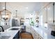 Bright kitchen with white cabinets, an island and stainless steel appliances at 48 Blue Heron Ln, Roxboro, NC 27574