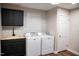The laundry room has matte black cabinets, wood countertop, shiplap, a sink, and new front load washer and dryer at 48 Blue Heron Ln, Roxboro, NC 27574