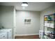 Laundry room with washer and dryer, storage shelves, and bright overhead lighting at 48 Blue Heron Ln, Roxboro, NC 27574