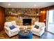 Comfortable living room with stone fireplace, chairs, and wood-look laminate flooring at 48 Blue Heron Ln, Roxboro, NC 27574
