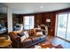 Inviting living room features a stone fireplace, leather sofa, and sliding glass doors to the backyard at 48 Blue Heron Ln, Roxboro, NC 27574