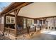 The covered porch features outdoor seating, stone accents, and wooded surroundings at 48 Blue Heron Ln, Roxboro, NC 27574