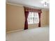 Bedroom features neutral colored walls, plush carpet, and large windows adorned with decorative drapes at 5036 Isabella Cannon Dr, Raleigh, NC 27612