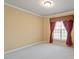 Bedroom with neutral carpet, one window with decorative curtains, and natural light at 5036 Isabella Cannon Dr, Raleigh, NC 27612
