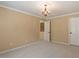 Neutral bedroom with white doors, plush carpeting, and elegant chandelier at 5036 Isabella Cannon Dr, Raleigh, NC 27612