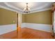 Dining area with hardwood floors, white trim, and contemporary light fixture at 5036 Isabella Cannon Dr, Raleigh, NC 27612