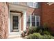 Elegant front entrance featuring brick facade, white pillars, and manicured greenery at 5036 Isabella Cannon Dr, Raleigh, NC 27612