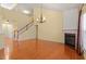 Open living room with fireplace, staircase, chandelier and ample natural light at 5036 Isabella Cannon Dr, Raleigh, NC 27612