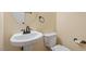 Well-lit powder room with pedestal sink, bronze fixtures and tile floors at 5036 Isabella Cannon Dr, Raleigh, NC 27612
