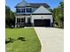 Charming two-story home featuring a well-manicured lawn, a two car garage, and stone accents at 60 Moonraker Dr, Spring Hope, NC 27882