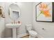 Bathroom with a pedestal sink, decorative mirror, toilet, and stylish artwork at 607 Callan View Ave, Wake Forest, NC 27587