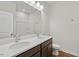 Bright bathroom featuring double sinks, a large mirror, and dark wood cabinets at 607 Callan View Ave, Wake Forest, NC 27587