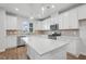 Modern kitchen featuring stainless steel appliances, white cabinetry, and an island with quartz countertops at 607 Callan View Ave, Wake Forest, NC 27587