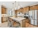 Modern kitchen boasts wooden cabinetry, stainless steel appliances, a center island with white countertops, and stylish pendant lighting at 607 Callan View Ave, Wake Forest, NC 27587