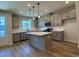 Modern kitchen boasts gray cabinetry, stainless steel appliances, a center island with white countertops, and stylish pendant lighting at 607 Callan View Ave, Wake Forest, NC 27587