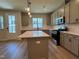 Modern kitchen boasts gray cabinetry, stainless steel appliances, a center island with white countertops, and stylish pendant lighting at 607 Callan View Ave, Wake Forest, NC 27587