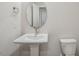 Clean, well-lit powder room featuring a pedestal sink, oval mirror, and modern fixtures at 607 Callan View Ave, Wake Forest, NC 27587