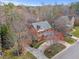 Aerial view of a well-maintained brick home surrounded by mature trees and lush landscaping at 6116 Wilkinsburg Rd, Raleigh, NC 27612
