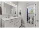 Bright bathroom with a dual sink vanity, marble countertops, and updated fixtures at 6116 Wilkinsburg Rd, Raleigh, NC 27612