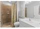 Tiled bathroom featuring a walk-in shower, white cabinets, and a modern sink at 6116 Wilkinsburg Rd, Raleigh, NC 27612