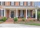 Inviting covered front porch with rocking chairs, brick flooring, and well-maintained landscaping at 6116 Wilkinsburg Rd, Raleigh, NC 27612