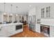 Bright kitchen with white cabinets, stainless steel appliances, wine fridge and hardwood floors at 6116 Wilkinsburg Rd, Raleigh, NC 27612