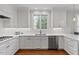 Bright kitchen with white cabinets, stainless steel appliances and hardwood floors at 6116 Wilkinsburg Rd, Raleigh, NC 27612