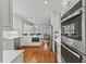 Bright kitchen with white cabinets and stainless steel appliances and hardwood floors at 6116 Wilkinsburg Rd, Raleigh, NC 27612