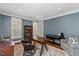 Comfortable living room with a dark wood desk, chair, piano and decorative rug at 6116 Wilkinsburg Rd, Raleigh, NC 27612
