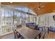 Spacious screened-in porch with a wood ceiling, ceiling fan, and outdoor dining and seating areas at 6116 Wilkinsburg Rd, Raleigh, NC 27612