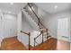 Staircase with hardwood floors, wooden railings, and natural light from nearby windows at 6116 Wilkinsburg Rd, Raleigh, NC 27612