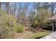 Lush backyard view featuring mature trees and greenery, offering a private and serene outdoor space at 615 Sloan Dr, Cary, NC 27511