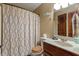 Bathroom featuring a shower with patterned curtains, toilet, vanity, and dark wood door at 6160 Virgilina Rd, Roxboro, NC 27574